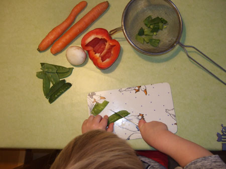 Kind beim Schneiden von Gemüse